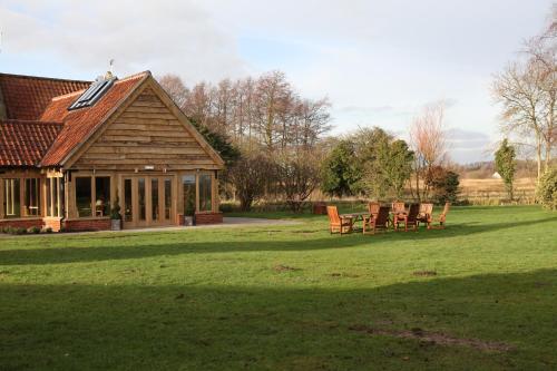 a house with chairs sitting in the grass at Ivy House Country Hotel in Lowestoft