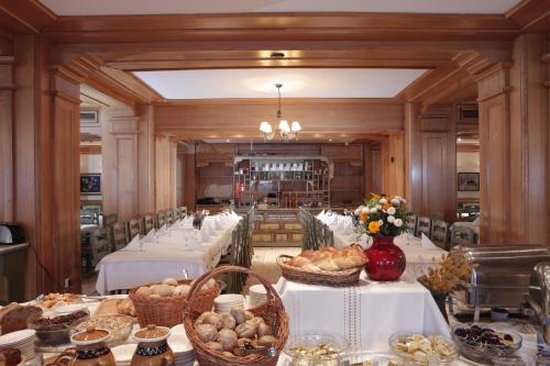 a long dining room with tables and baskets of food at Hotel Best Western Bucovina in Gura Humorului