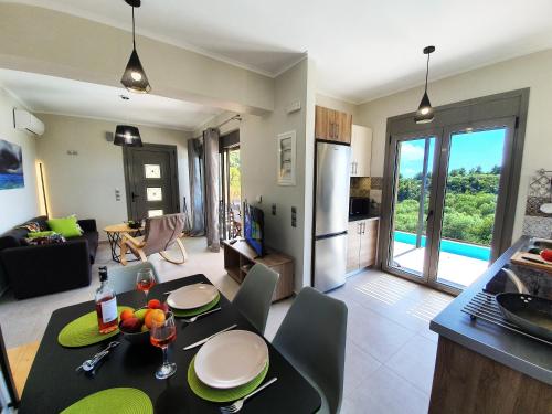 eine Küche und ein Wohnzimmer mit einem Tisch und Stühlen in der Unterkunft Villa euphoria in Agios Nikitas