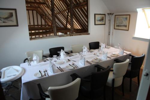 a room with a long table with white tables and chairs at Ivy House Country Hotel in Lowestoft