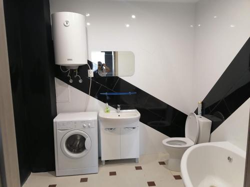 a bathroom with a washing machine and a toilet at Mini-otel on Harkivske shose in Kyiv