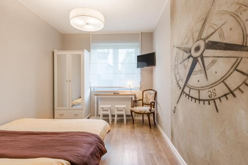 a room with two beds and a clock on the wall at Morze u Moni in Karwieńskie Błoto Pierwsze