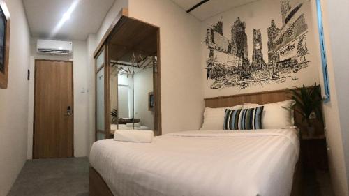 um quarto com uma grande cama branca e um espelho em Casa Living Senayan Hotel em Jakarta