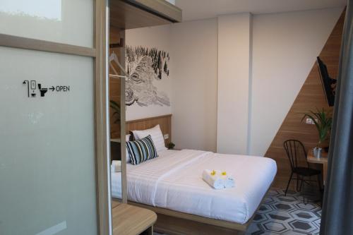 um pequeno quarto com uma cama e uma mesa em Casa Living Senayan Hotel em Jakarta