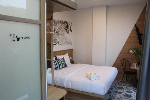 a small room with a bed and a table at Casa Living Senayan Hotel in Jakarta