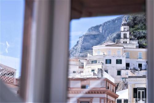 a view of a building with a mountain in the background at Zia Pupetta Suites in Amalfi