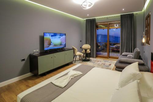 a bedroom with a large bed and a television in it at Villa Kristiano 21 in Sarandë