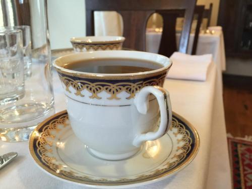 a cup of coffee on a plate on a table at Dartmouth House in Rochester