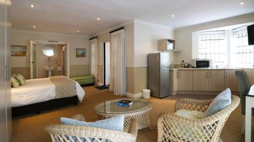 ポートエリザベスにあるFifth Avenue Beach Houseのベッドとテーブルと椅子のあるホテルの部屋