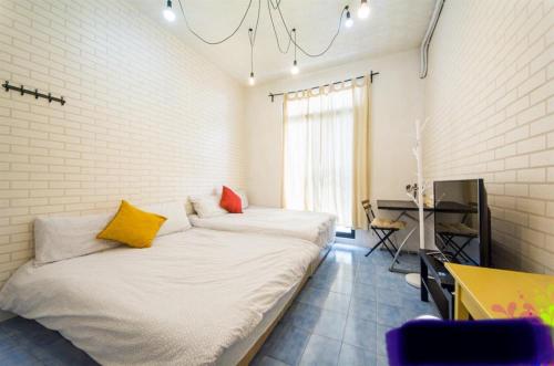 台南的住宿－沐森旅宿，一间卧室配有一张大床,提供黄色和红色枕头