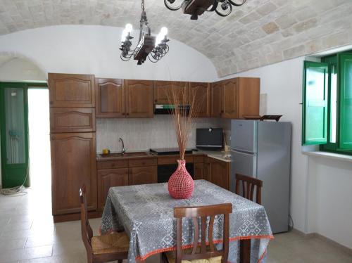 a kitchen with a table with a vase on it at Trullo Le Tre Sorelle in Cisternino