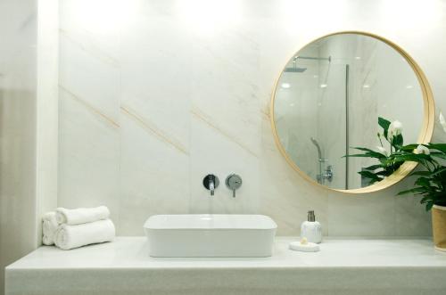a white bathroom with a sink and a mirror at Villa Elia II in Mélanes