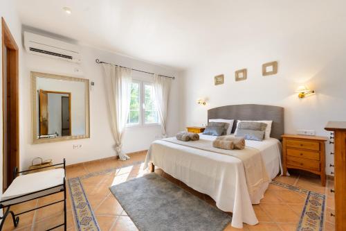 Un dormitorio con una cama grande y un espejo. en Casa Olivo, en Sant Josep de sa Talaia