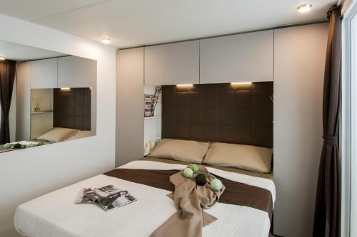 a bedroom with two beds and a mirror at Casa mobile - Marina di Venezia in Cavallino-Treporti