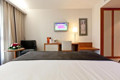 a hotel room with a bed and a desk at Hotel Mercure Lisboa in Lisbon