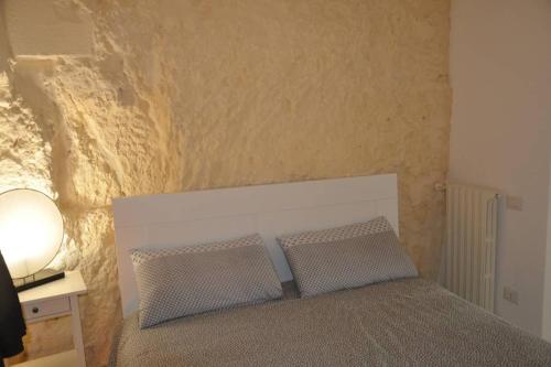 a bedroom with a bed with two pillows on it at La Sassolina appartamento in Matera