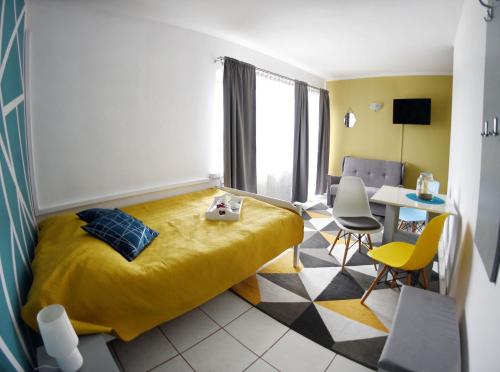 a bedroom with a yellow bed and a table and chairs at Marinas Rewa in Rewa
