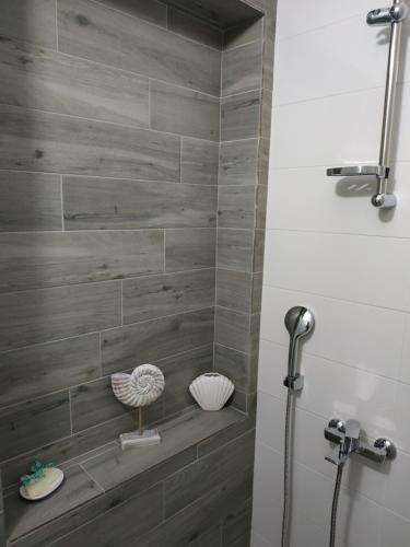 y baño con ducha de azulejos grises. en Arxontia 2 en Kalamata