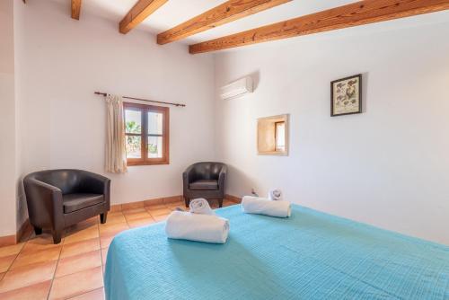 1 Schlafzimmer mit einem blauen Bett und 2 Stühlen in der Unterkunft Can Julia in Búger