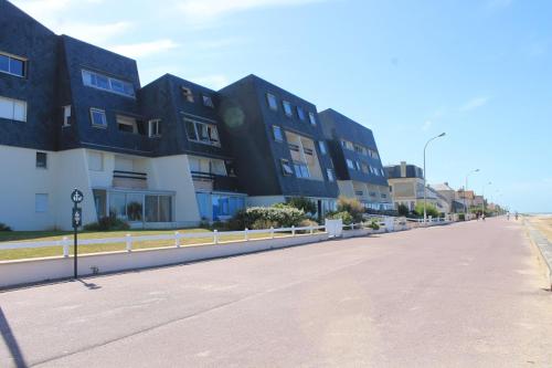 an empty street in front of a building at Beau Front de mer cosy accès direct plage St aubin sur mer in Bernières-sur-Mer