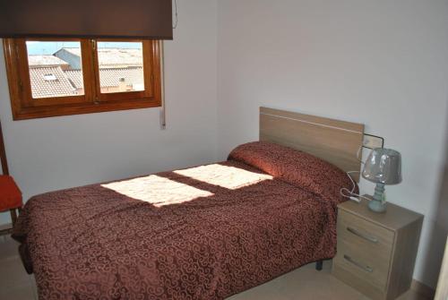 1 dormitorio con cama y ventana en APARTAMENTO TURISTICO EL ACEBO, en Jarandilla de la Vera