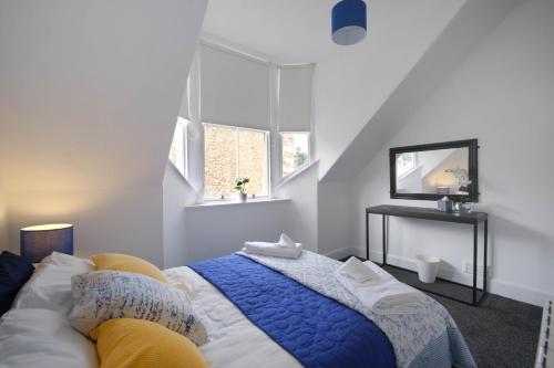 a bedroom with a bed with a blue blanket at Marys Garden View North in Jedburgh