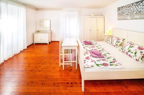 una camera da letto con un letto bianco e un tavolo di Apartmant Ivan a Malinska