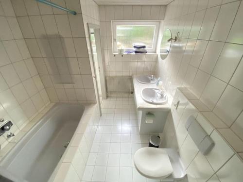 a bathroom with a toilet and a sink and a tub at Haus Höhneck 1 in Alpirsbach