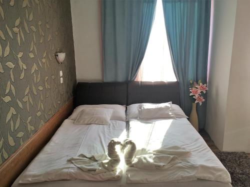 a bed with a pair of heartsacers at Európa Panzió in Mátészalka