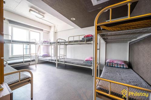 a room with several bunk beds in a building at Mamas and Papas Guesthouse and Apartments in Seoul in Seoul
