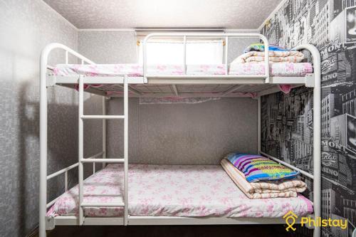 two bunk beds in a room with a wall at Mamas and Papas Guesthouse and Apartments in Seoul in Seoul