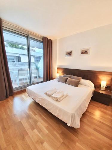 a bedroom with a large bed and a large window at Ancora Frontbeach Luxury Apartment in Tossa de Mar