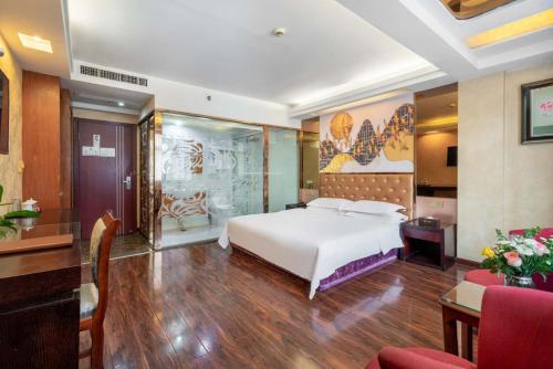 a hotel room with a bed and a table and chairs at Yiwu Yuejia Business Hotel in Yiwu