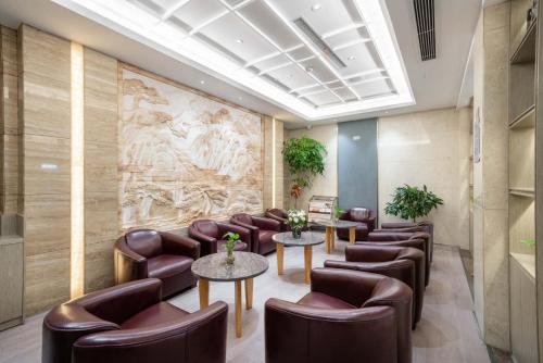 a waiting room with leather chairs and tables at Yiwu Yuejia Business Hotel in Yiwu