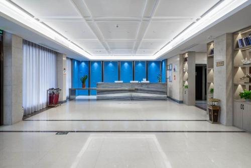 a large hallway with blue walls in a building at Yiwu Yuejia Business Hotel in Yiwu