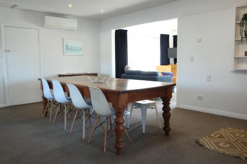 a dining room with a wooden table and chairs at 1 - Delightfully fresh, private home close to town in Wanaka