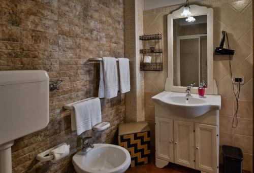 a bathroom with a sink and a toilet and a mirror at B&B Le Oasi in Terrasini