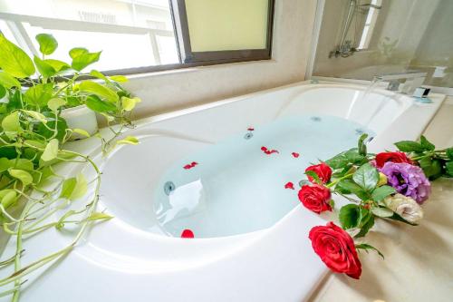台南的住宿－拍R平方電梯民宿，浴室配有带鲜花的浴缸。