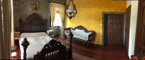 a bedroom with a bed and a chair and a door at O Pazo da Briona in Arzúa