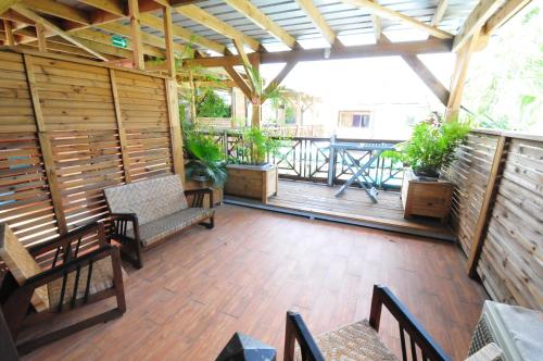 a large wooden deck with chairs and a table at SAS L' Ilot Vert in La Saline les Bains