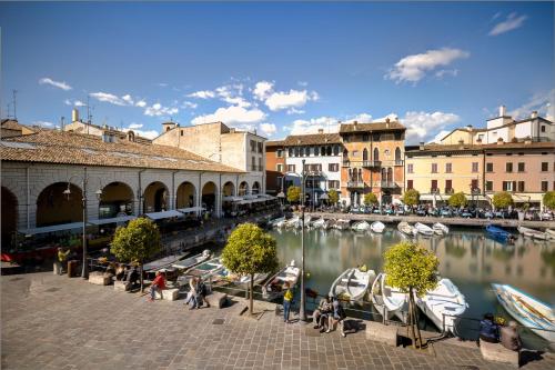 grupa łodzi jest zakotwiczona w przystani w obiekcie Hotel Piroscafo w mieście Desenzano del Garda