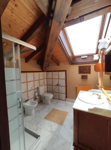 een badkamer met 2 toiletten en een dakraam bij Posada La Casa de Lastras in Ogarrio