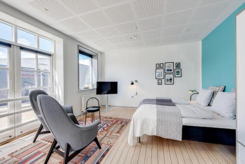1 dormitorio con cama, sofá y TV en Hvide Sande Hotel en Hvide Sande