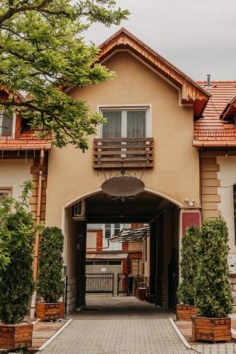 a house with a balcony on top of it at Páva City in Odorheiu Secuiesc