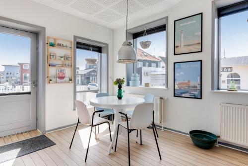 a dining room with a white table and chairs at Hvide Sande Hotel in Hvide Sande