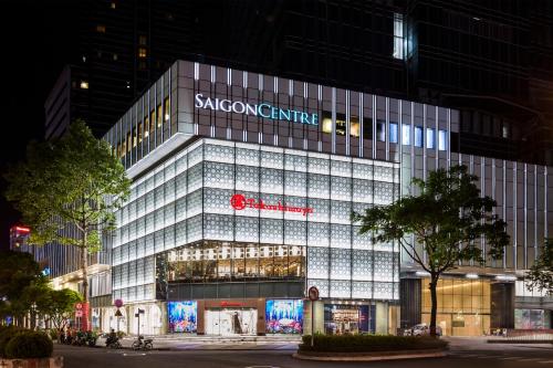 a large glass building with a sign on it at Sedona Suites Ho Chi Minh City in Ho Chi Minh City