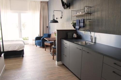 a kitchen with a sink and a bed in a room at De tien Wilgen in Oosterblokker