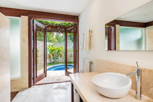 a bathroom with a sink and a mirror at Unique Villa with Ocean and River Views - Staff & Golf Carts in La Romana