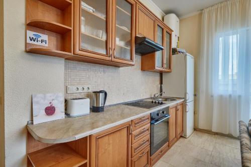 a kitchen with wooden cabinets and a counter top at Botanic Towers the house has a shelter in Kyiv