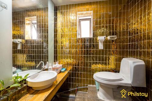 a bathroom with a toilet and a sink and a mirror at Mamas and Papas Guesthouse and Apartments in Seoul in Seoul